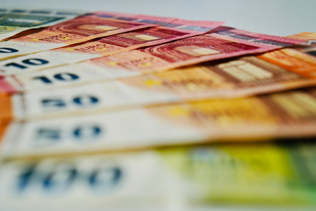 Services A close-up image of euro banknotes in various denominations spread out, showcasing currency details.