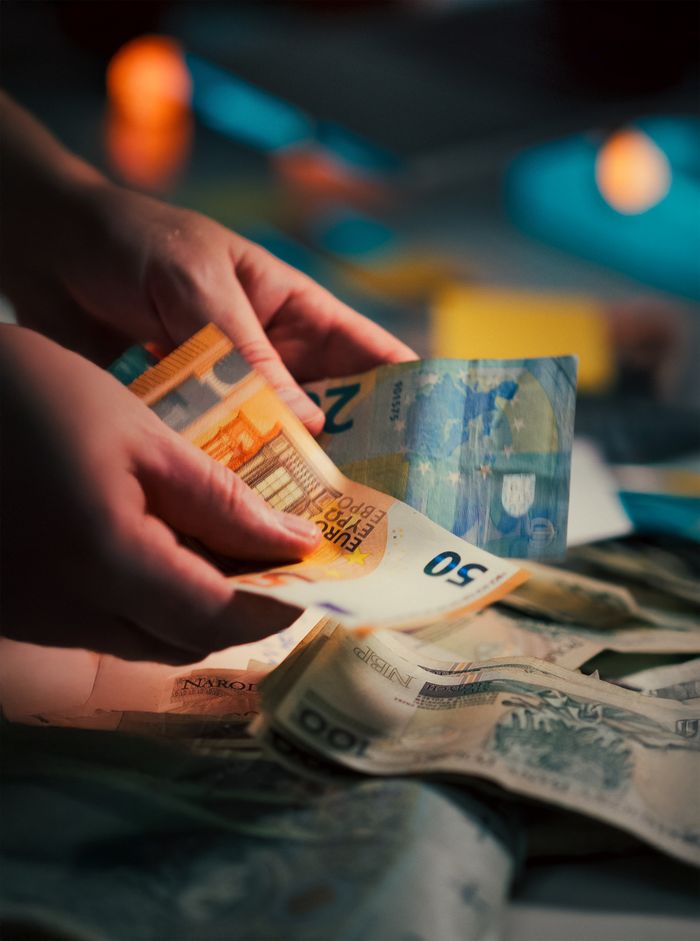 Services Hands counting assorted Euro banknotes, highlighting currency exchange and finance concepts.