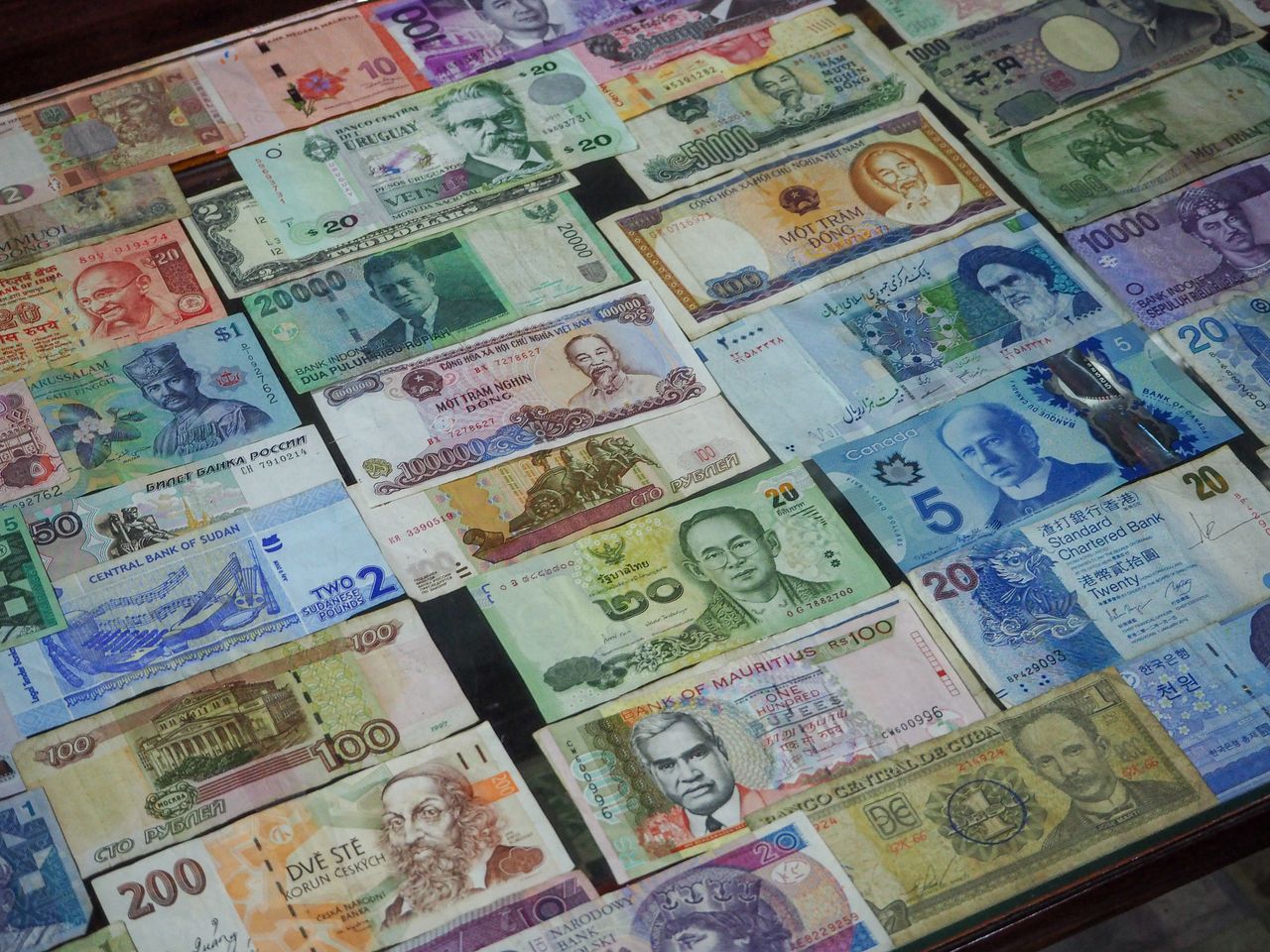 Services From above collection of various colorful banknotes from different countries arranged in row on table
